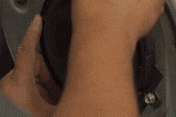 Close-up of a technician installing a speaker into a car door panel, highlighting the ideal season for a car audio upgrade.