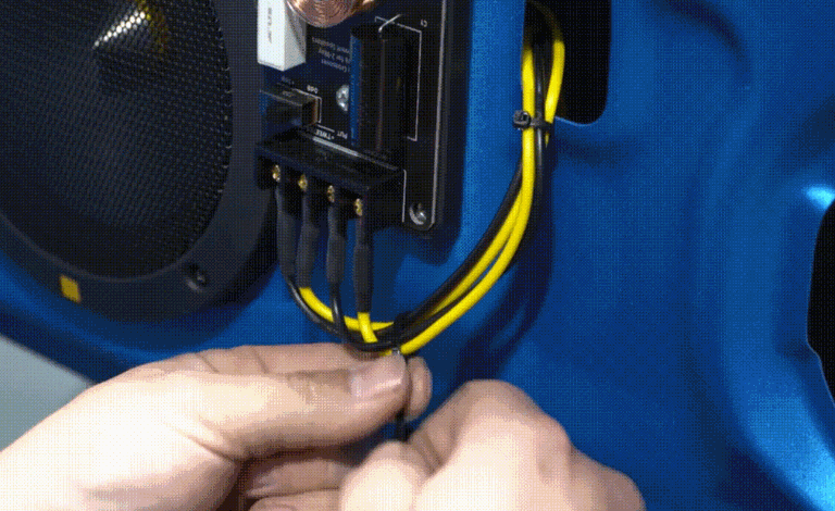 Technician wiring Best Car Audio system components inside a custom car audio installation setup